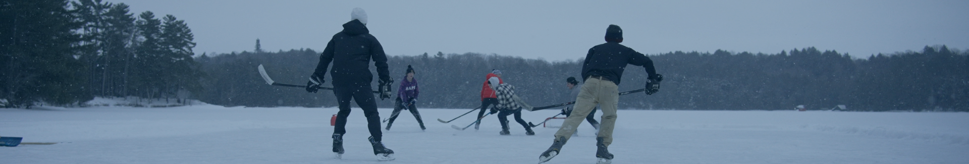 Skating on Lake Joseph in the winter as snow falls