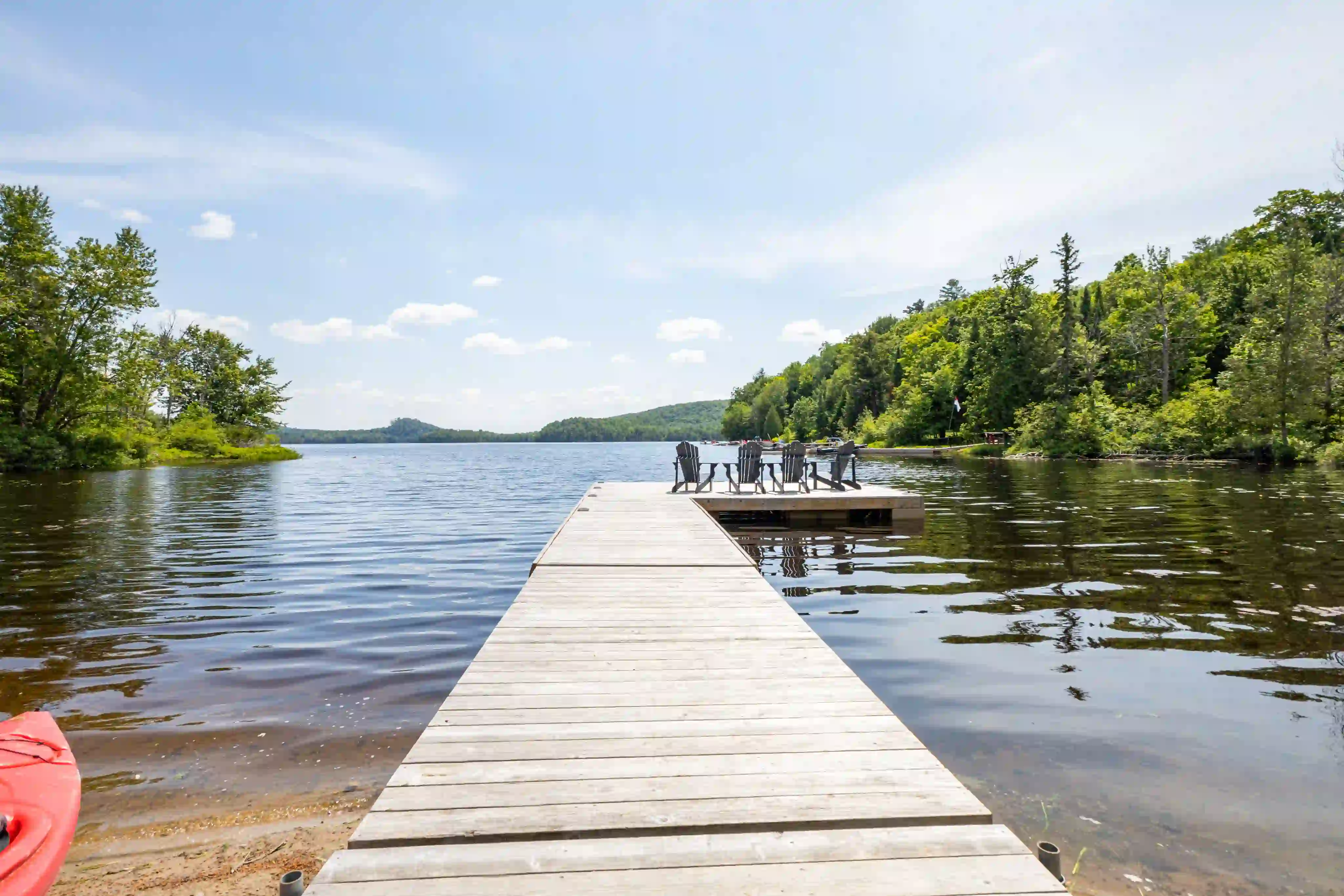 Scenic Ontario lake with a cottage dock and Adirondack chairs
